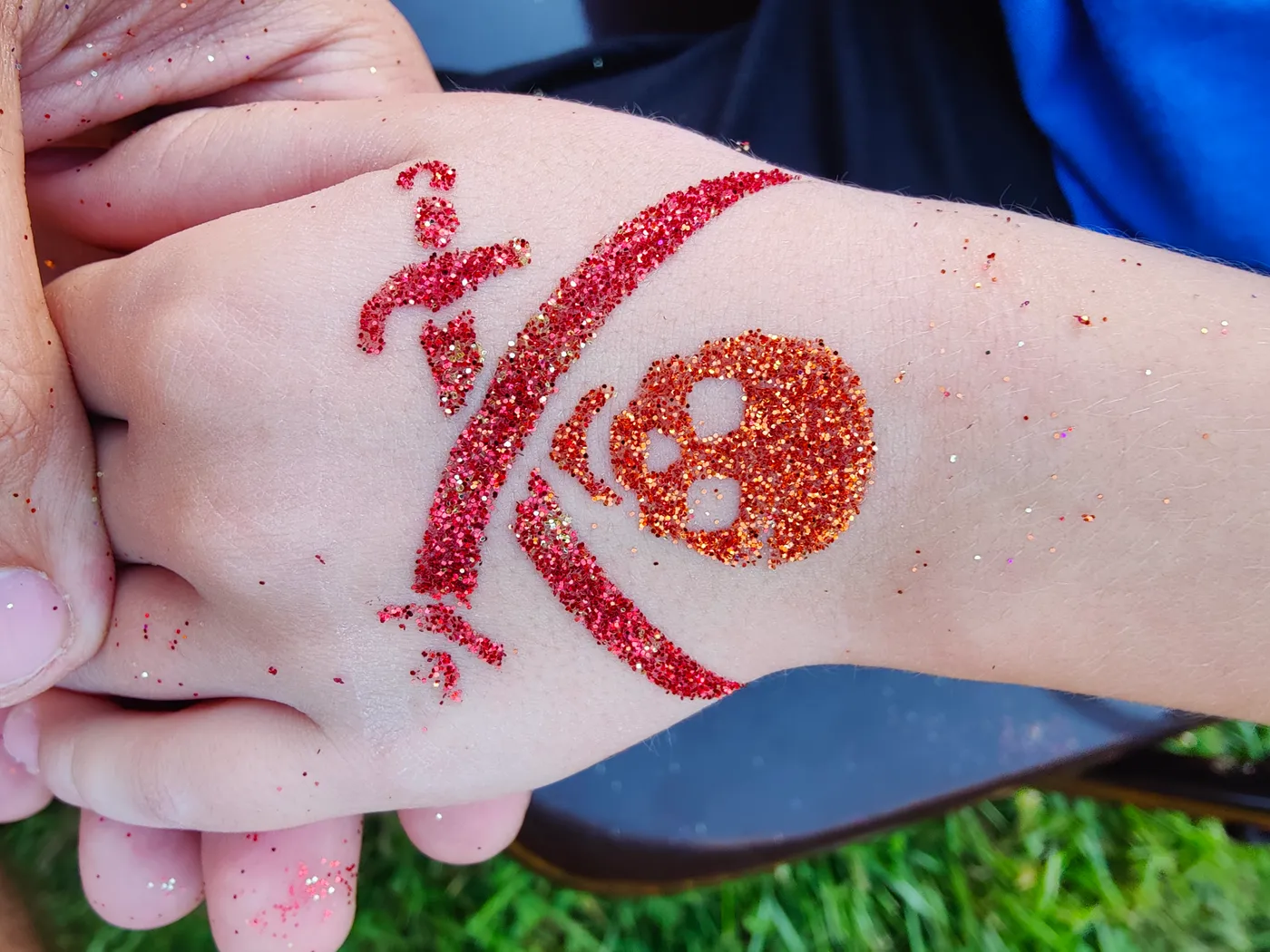 A red glitter design on a hand